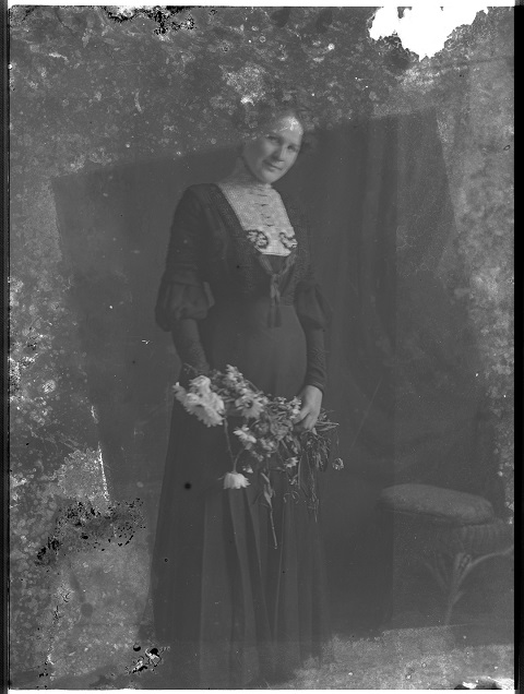 ​​​972-48     Unidentified woman with flowers, ca. 1900.
Decay to the glass negative gives her a ghostly appearance. 